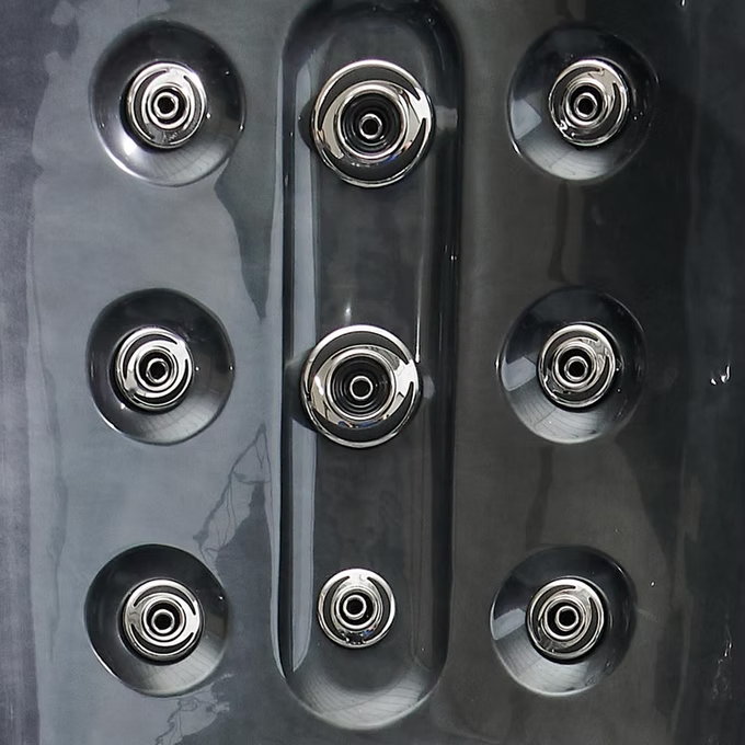 Six chrome-finished jet nozzles arranged in a symmetrical pattern on a dark, glossy surface.