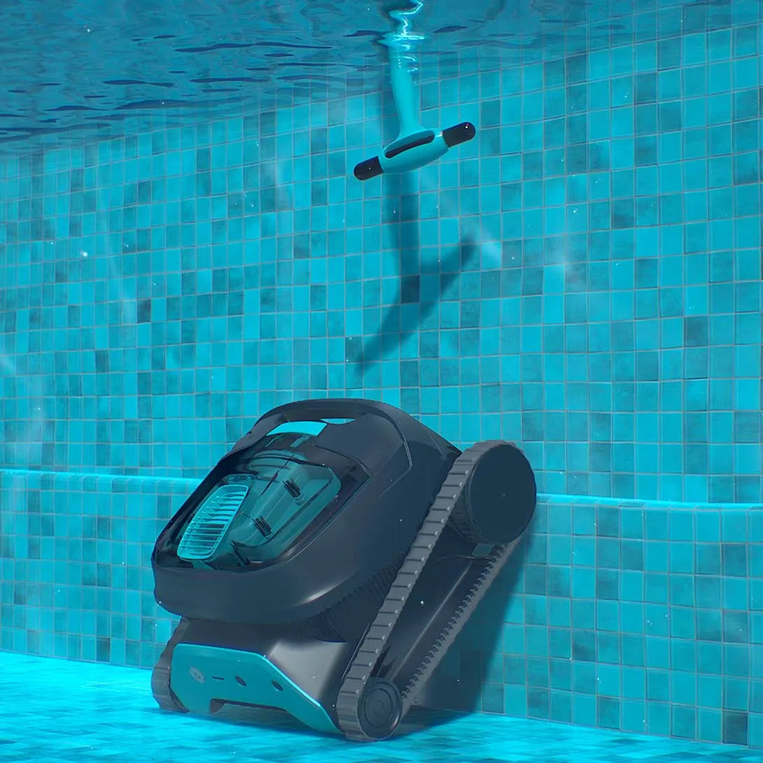 Black and teal robotic pool cleaner with tank-like body, tracked wheels, and a floating remote control device above the water.