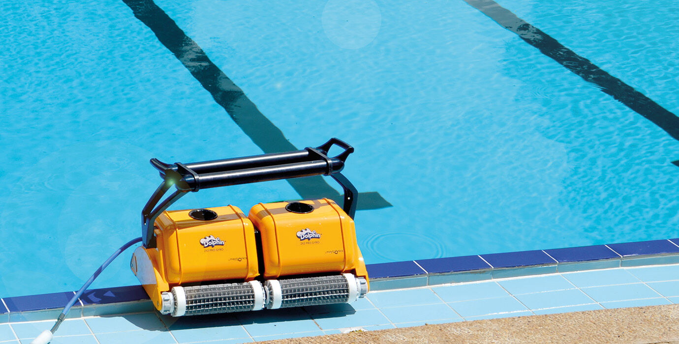 Yellow robotic pool cleaner with black handle and silver brush rollers.