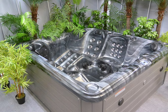 Gray and black marbled hot tub with multiple jet nozzles and a sleek, modern design.