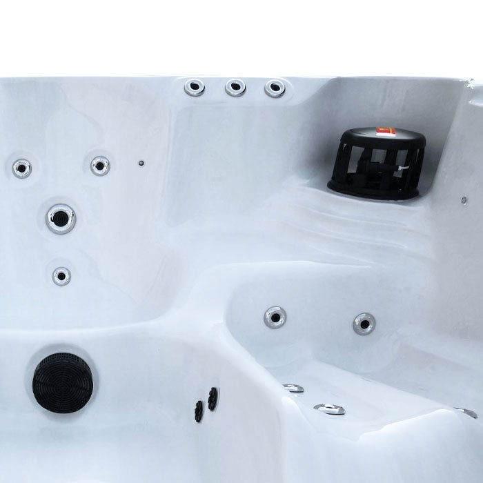 White hot tub with black jet covers and silver-toned jets.
