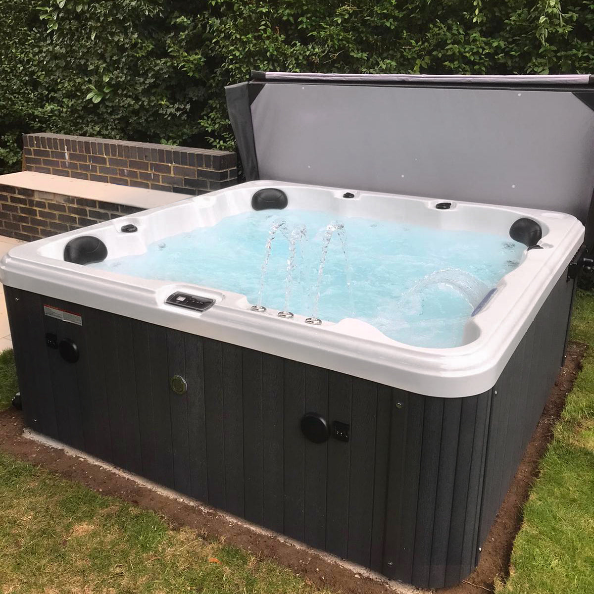 Black and white hot tub with water jets active