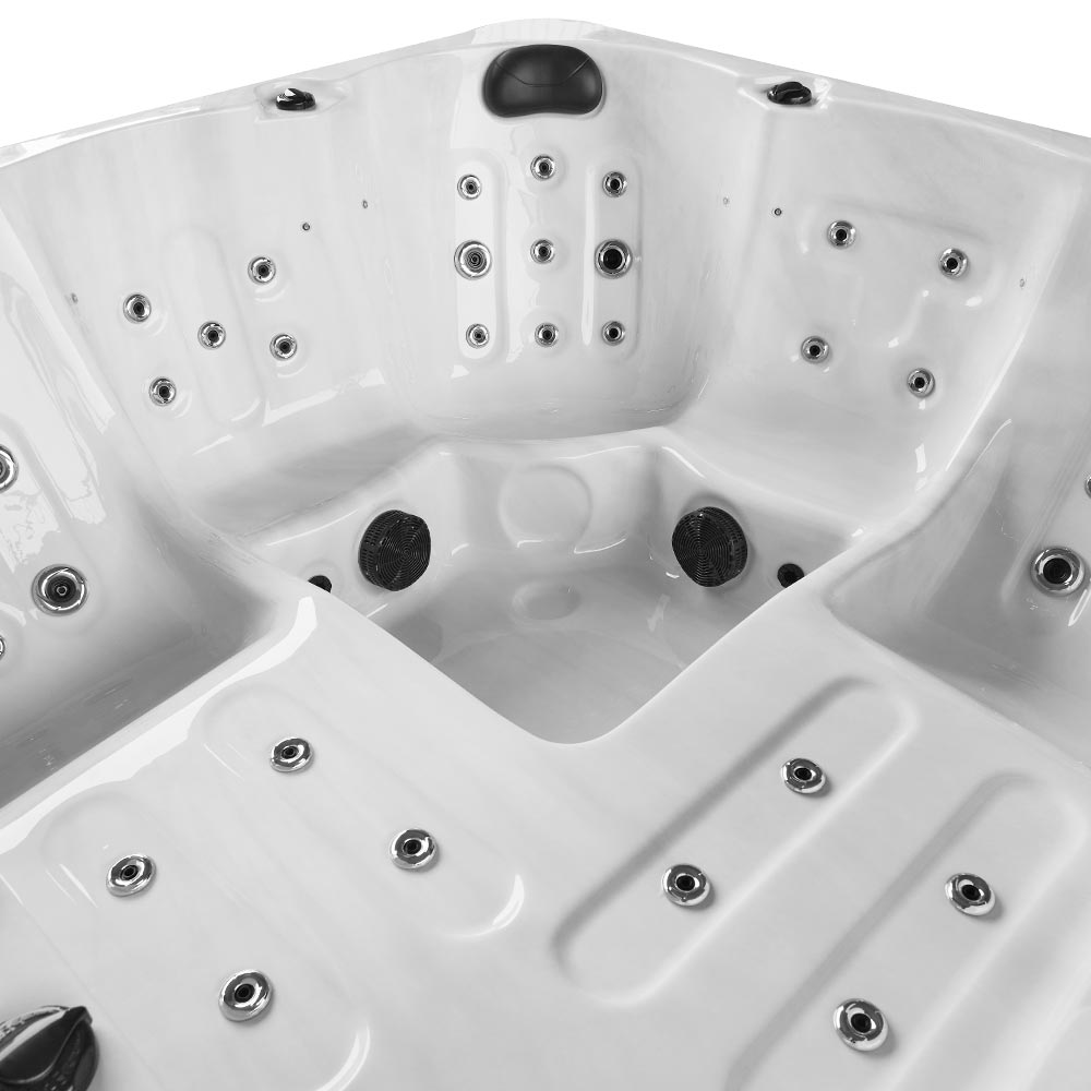 White hot tub with multiple jet nozzles and black circular massage jets.