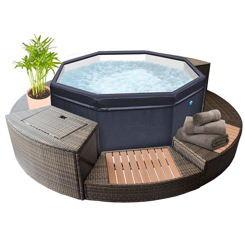 Dark blue octagonal hot tub with a textured fabric exterior and clear glass top, surrounded by woven wicker seating and wooden slats.