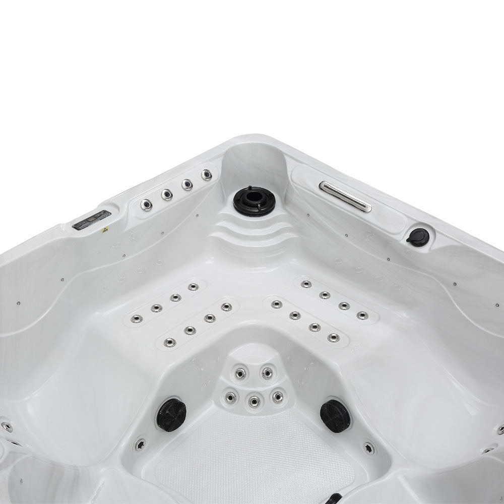White corner hot tub with black jet nozzles and silver control panel.