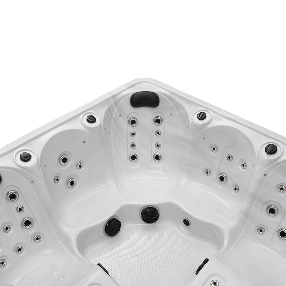White corner hot tub with black jets and silver-toned fixtures.