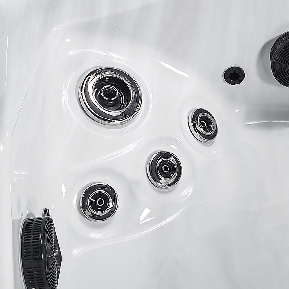 White hot tub with chrome-finished jet nozzles and black filtration components.