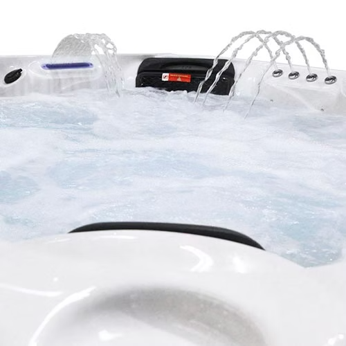 White hot tub with black control panel and water jets spraying.