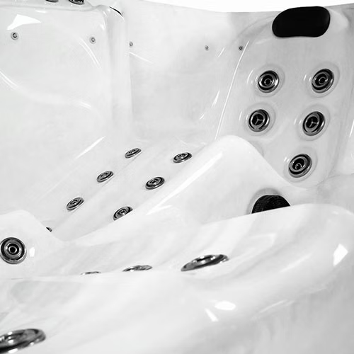 White hot tub with multiple silver jet nozzles embedded in its curved, molded surfaces.