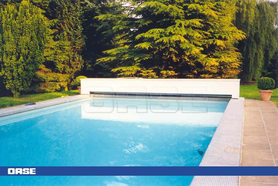 Rectangular in shape with clear blue water and a white concrete surround, featuring the oase brand logo prominently displayed on its side.