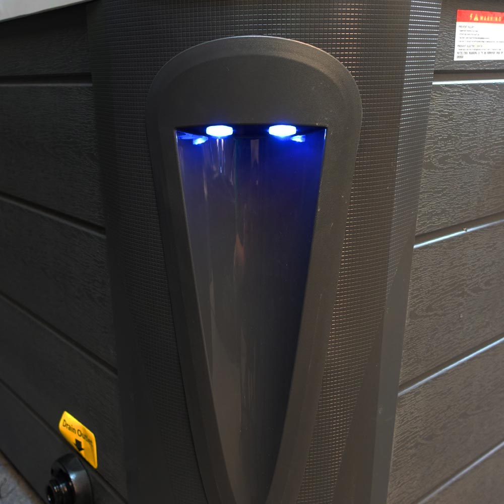 Black plastic water heater with blue led lights illuminating a vertical, arched opening.