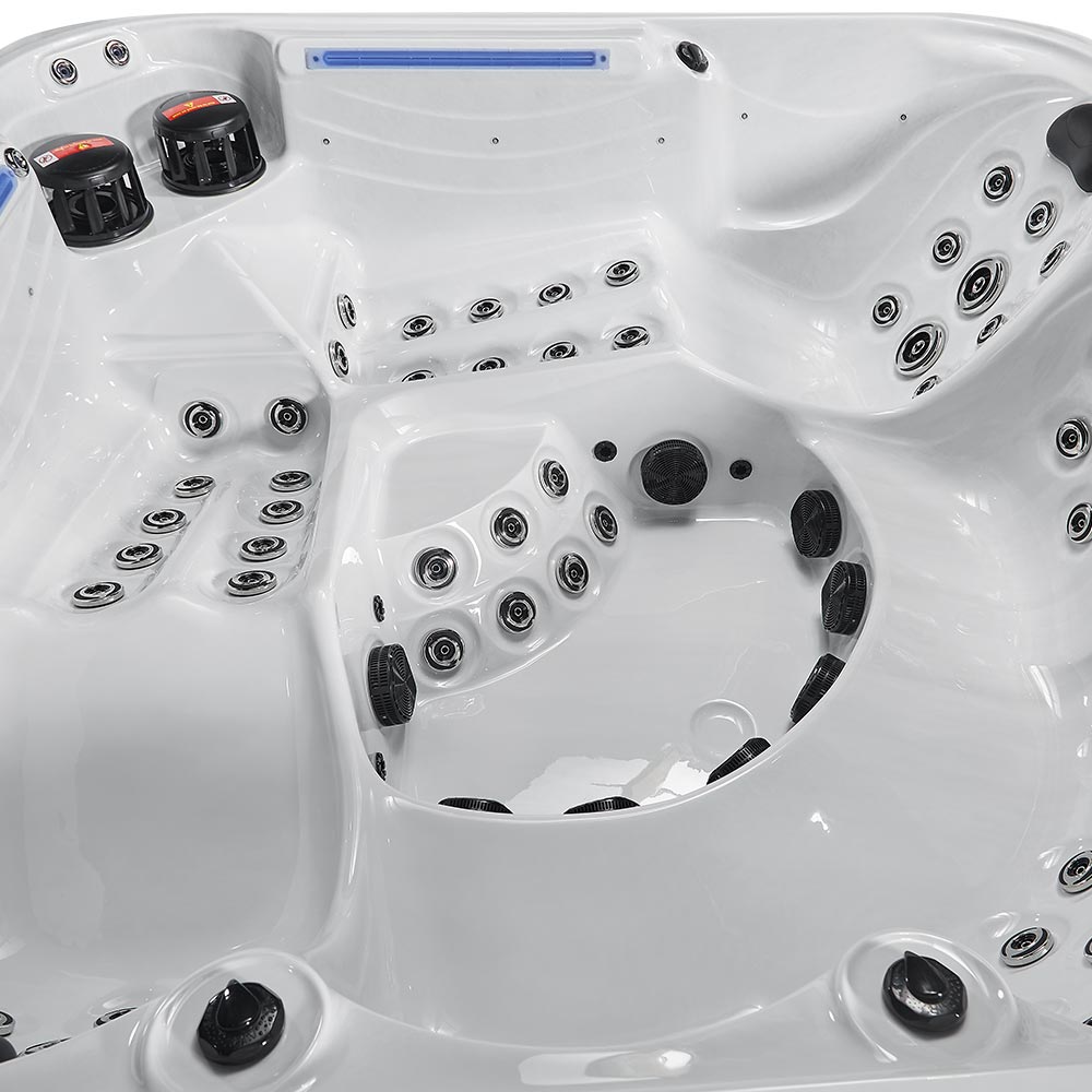 White hot tub with black jet nozzles and control panels.