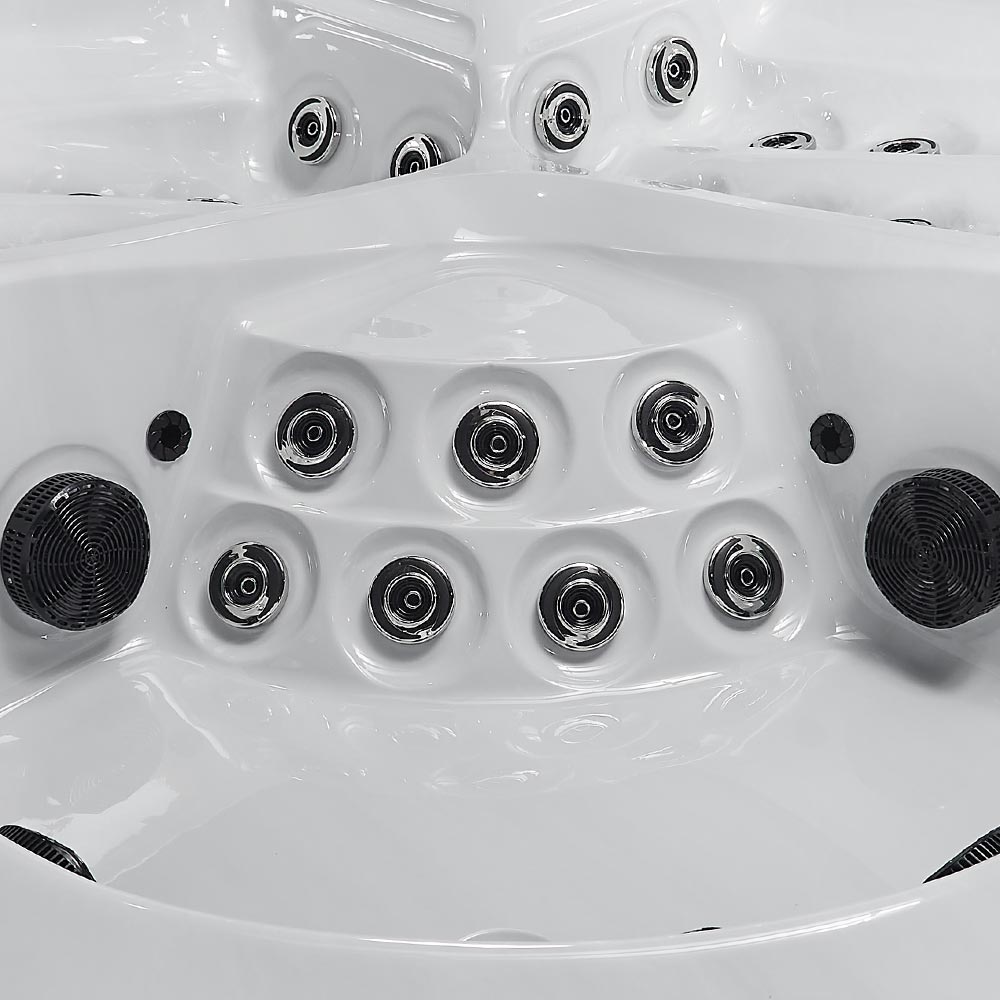 White hot tub with black jet nozzles and circular speaker grilles.
