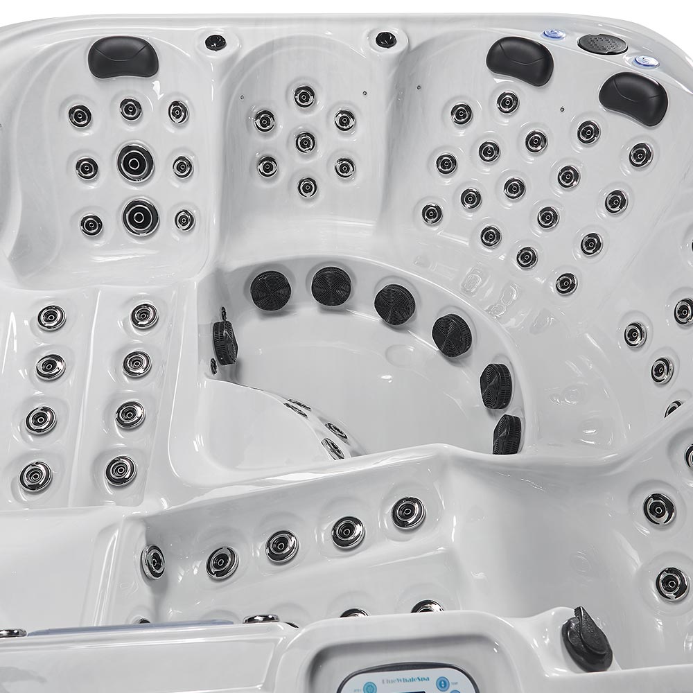 White hot tub with black jet nozzles and control panel.