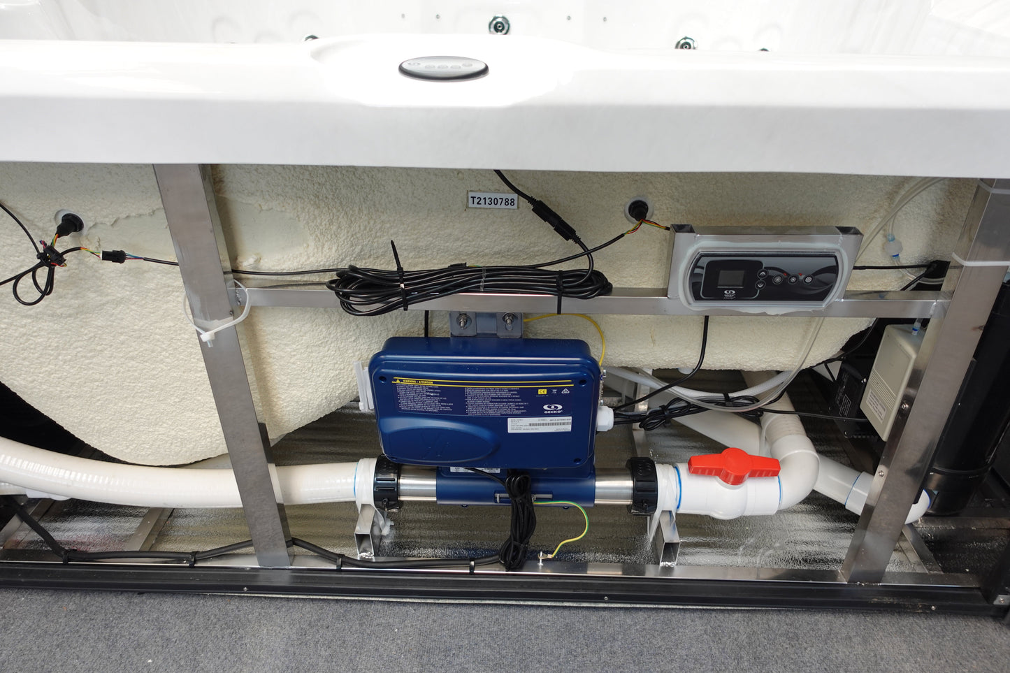 Blue rectangular spa filtration pump with white pipes and a red valve attached to it