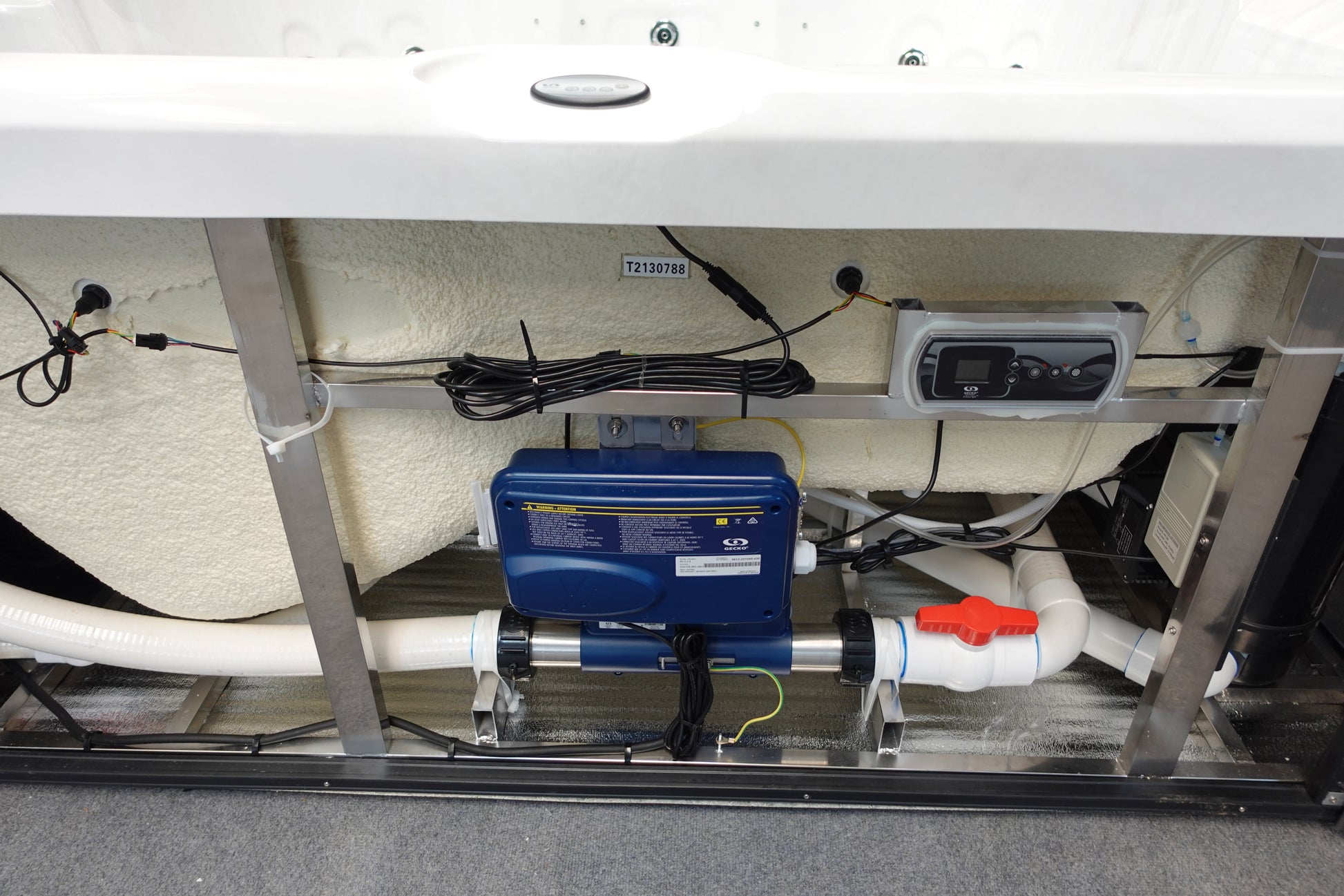 Blue rectangular spa filtration pump with white pipes and a red valve attached to it