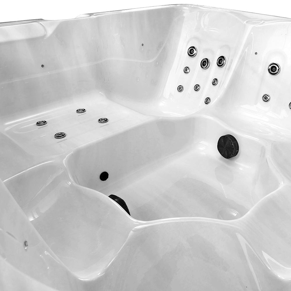 White hot tub with multiple black jet nozzles embedded in its molded surface.