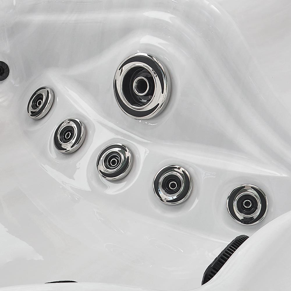 Chrome-finished jet nozzles embedded in a white hot tub surface.
