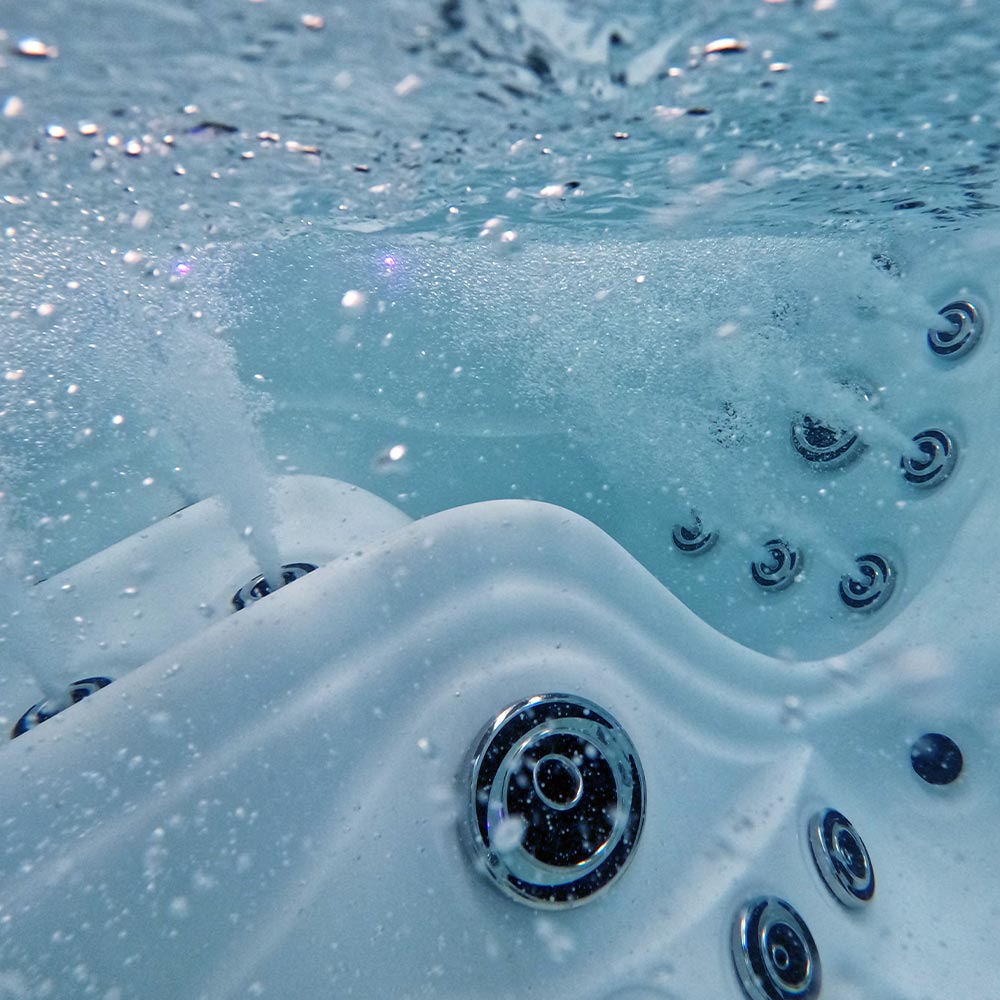 White hot tub with chrome jets and bubbling water.