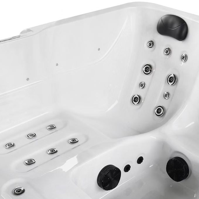 White hot tub with black jet nozzles and circular chrome fixtures.