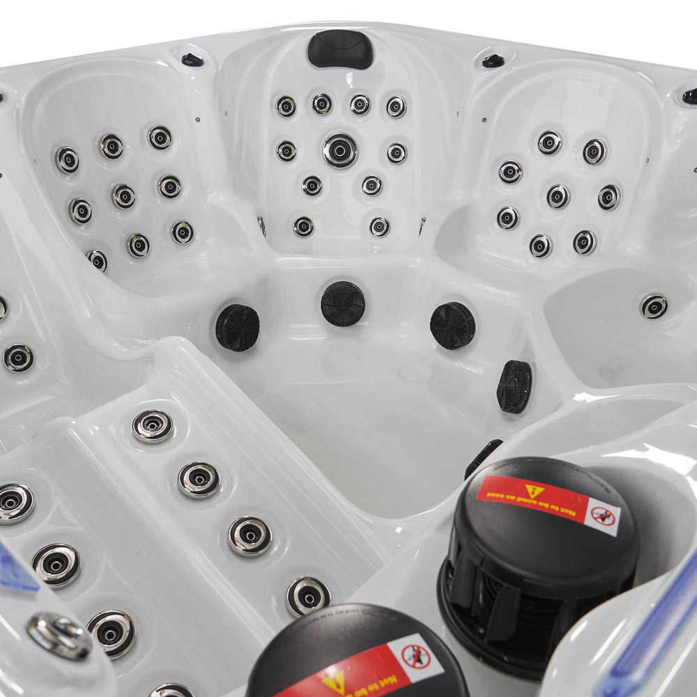 White hot tub with black jets and circular chrome nozzles.