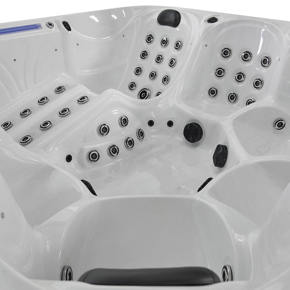 White hot tub with multiple black jet nozzles and molded seating areas.