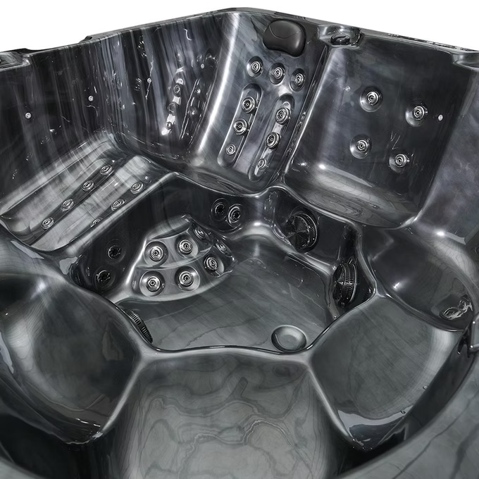 Black hot tub with multiple jet nozzles and contoured seating.