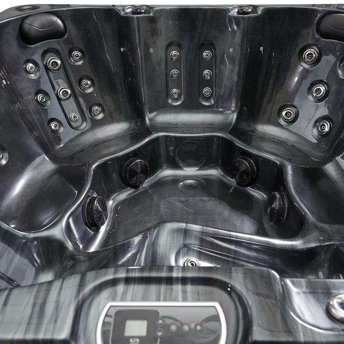 Black hot tub with multiple jet nozzles and a control panel.
