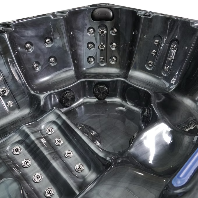 Black plastic hot tub with multiple jet nozzles and a glossy finish.