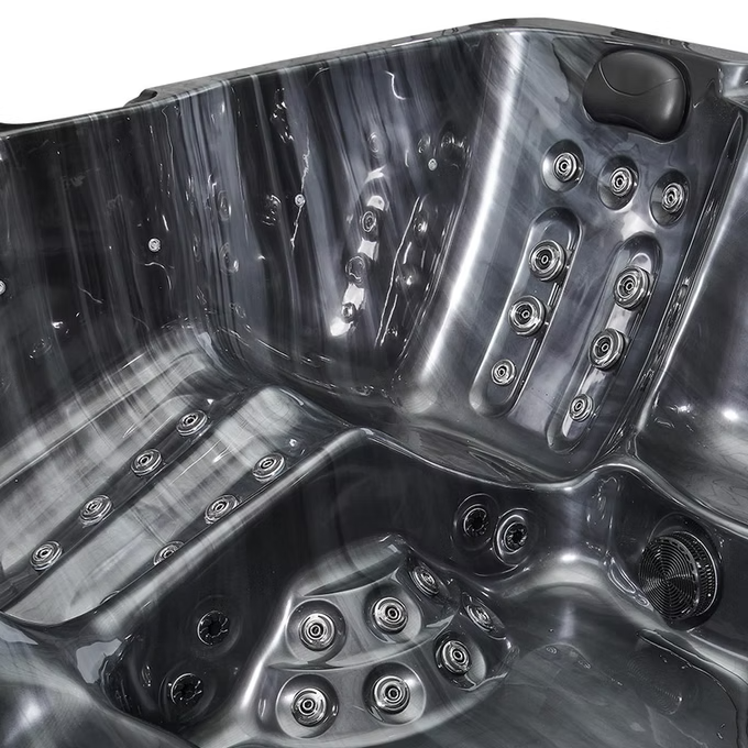 Black textured hot tub with multiple jet nozzles and a sleek, modern design.
