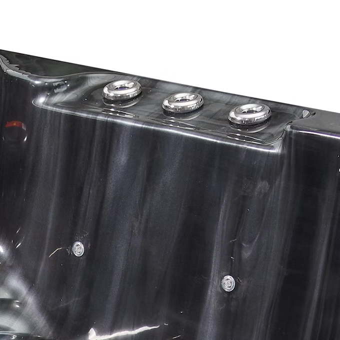 Black hot tub with three silver circular jets along the top edge.
