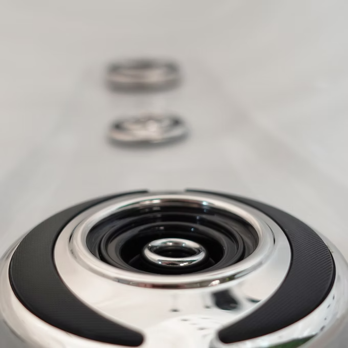 Silver and black circular speaker with a glossy metallic finish.