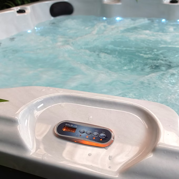 White plastic control panel with orange-lit digital display and buttons for a balboa hot tub.