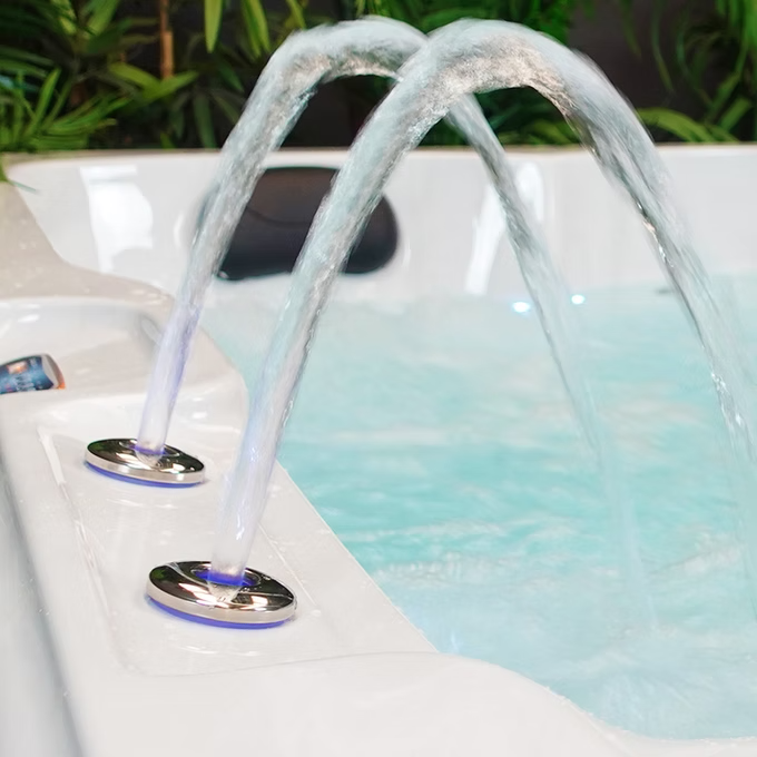 White hot tub with two arched water jets emitting clear, flowing streams of water.