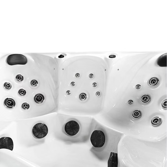 White hot tub with black jet nozzles and circular chrome fixtures.