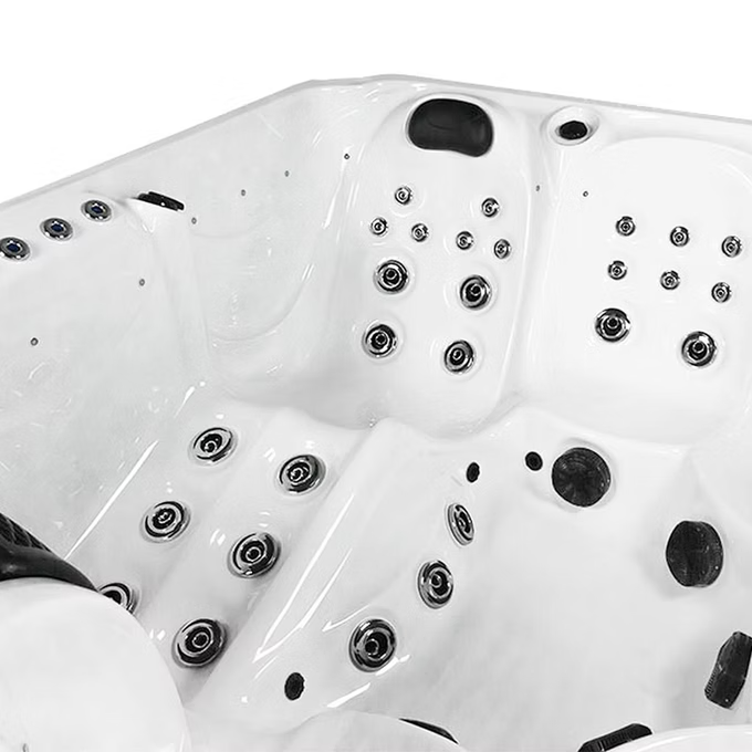 White hot tub with black jet nozzles and chrome accents.