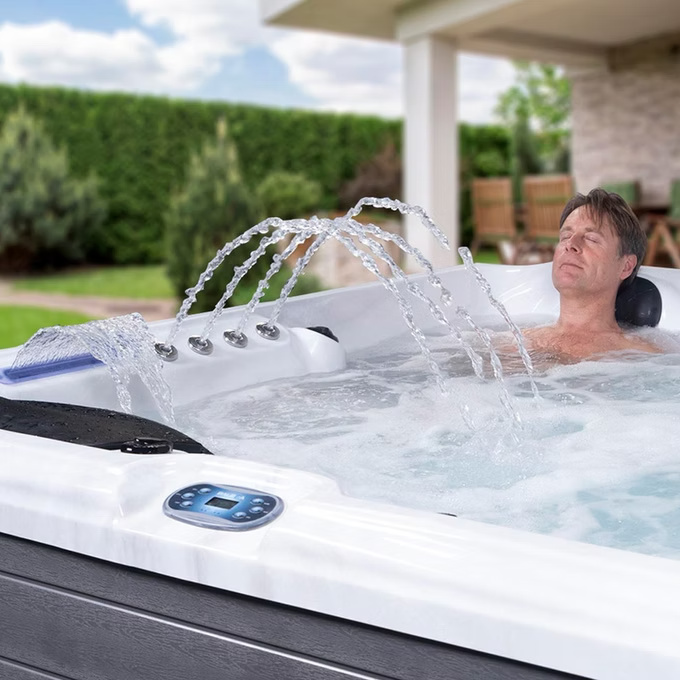 White and gray hot tub with water jets spraying upward.